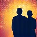 A silhouette of a retired couple looking at a world map.